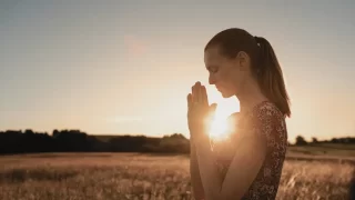 自然の中で祈る女性
